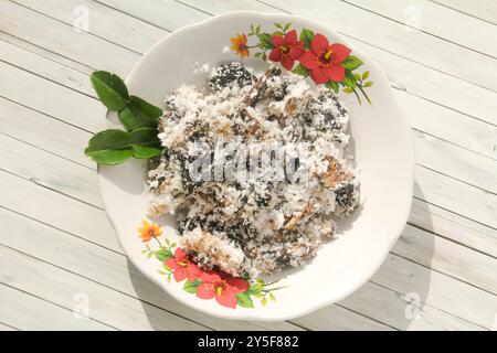 Gatot mit geriebenem Kokosnussbelag, Gatot ist ein typisches indonesisches Essen, das aus Maniok hergestellt wird, das einige Zeit getrocknet wird, um einen unverwechselbaren Bla zu produzieren Stockfoto