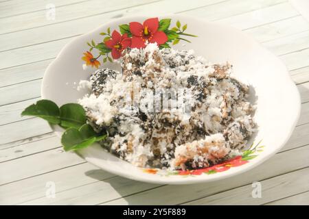 Gatot mit geriebenem Kokosnussbelag, Gatot ist ein typisches indonesisches Essen, das aus Maniok hergestellt wird, das einige Zeit getrocknet wird, um einen unverwechselbaren Bla zu produzieren Stockfoto