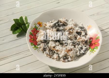 Gatot mit geriebenem Kokosnussbelag, Gatot ist ein typisches indonesisches Essen, das aus Maniok hergestellt wird, das einige Zeit getrocknet wird, um einen unverwechselbaren Bla zu produzieren Stockfoto