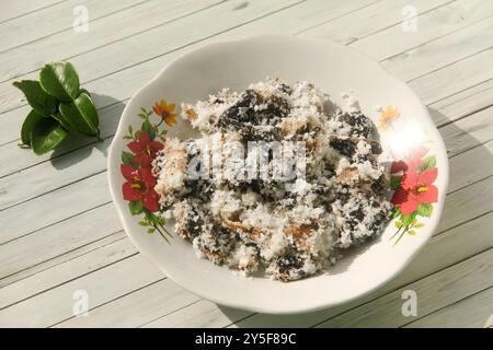 Gatot mit geriebenem Kokosnussbelag, Gatot ist ein typisches indonesisches Essen, das aus Maniok hergestellt wird, das einige Zeit getrocknet wird, um einen unverwechselbaren Bla zu produzieren Stockfoto