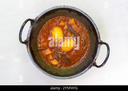 Scharfer Dim Bhuna oder Dim Vuna, gekocht mit Kartoffeln in einem Karai. Dieses köstliche Bengali gekochte Eiercurry wird oft mit Reis oder Brot genossen. Stockfoto