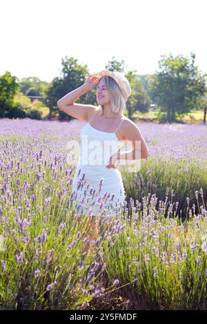 Vertikale Portrait individuelle glückliche junge kaukasische Frau im Lavendelfeld. Stockfoto