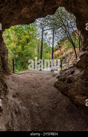 Blick aus dem Inneren einer Höhle auf die eiserne Brücke auf dem Castril River Gorge Trail. Stockfoto