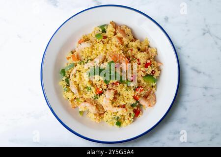 Couscous-Salat mit Gemüse und Garnelen. Tisch mit Draufsicht und Dekoration. Stockfoto