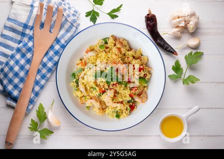 Couscous-Salat mit Gemüse und Garnelen. Tisch mit Draufsicht und Dekoration. Stockfoto