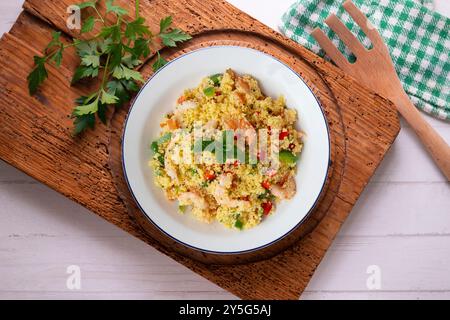 Couscous-Salat mit Gemüse und Garnelen. Tisch mit Draufsicht und Dekoration. Stockfoto