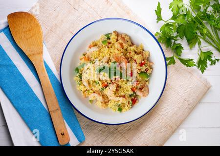 Couscous-Salat mit Gemüse und Garnelen. Tisch mit Draufsicht und Dekoration. Stockfoto