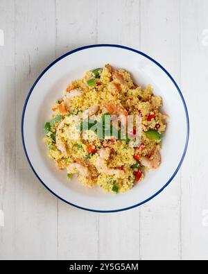 Couscous-Salat mit Gemüse und Garnelen. Tisch mit Draufsicht und Dekoration. Stockfoto