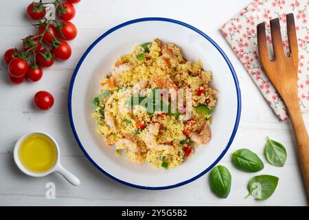 Couscous-Salat mit Gemüse und Garnelen. Tisch mit Draufsicht und Dekoration. Stockfoto