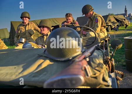 Die Reenactoren, die in einem originalen Jeep aus dem Jahr 1944 warteten. Diese Reenactors üben die Nachstellung der „Kreuzung der Waal“. Die Praxis fand am Fluss Waal in einem Überlaufgebiet namens Nevengeul statt. Hier befindet sich auch das Denkmal auf dem Deich. Vor 80 Jahren überquerten 260 Soldaten der 82. Luftlandedivision die Waal in 26 Segelbooten, um die Waal-Brücke gleichzeitig von Süden und Osten anzugreifen. Die Hälfte der 260 Soldaten wurde verletzt und 48 wurden bei dieser Aktion getötet. Es ist nicht bekannt, wie viele deutsche Soldaten bei dieser Aktion starben. Stockfoto