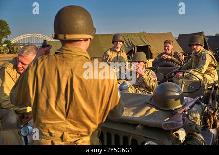 Die Reenactoren, die in einem originalen Jeep aus dem Jahr 1944 warteten. Diese Reenactors üben die Nachstellung der „Kreuzung der Waal“. Die Praxis fand am Fluss Waal in einem Überlaufgebiet namens Nevengeul statt. Hier befindet sich auch das Denkmal auf dem Deich. Vor 80 Jahren überquerten 260 Soldaten der 82. Luftlandedivision die Waal in 26 Segelbooten, um die Waal-Brücke gleichzeitig von Süden und Osten anzugreifen. Die Hälfte der 260 Soldaten wurde verletzt und 48 wurden bei dieser Aktion getötet. Es ist nicht bekannt, wie viele deutsche Soldaten bei dieser Aktion starben. Stockfoto