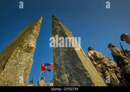 Nijmegen, Gelderland, Niederlande. September 2024. Das Gedenken wird am Denkmal des Waal-Kreuzes praktiziert. Auf der rechten Seite befinden sich die Reenactor zwischen dem Denkmal. Diese Reenactors üben die Nachstellung der „Kreuzung der Waal“. Die Praxis fand am Fluss Waal in einem Überlaufgebiet namens Nevengeul statt. Hier befindet sich auch das Denkmal auf dem Deich. Vor 80 Jahren überquerten 260 Soldaten der 82. Luftlandedivision die Waal in 26 Segelbooten, um die Waal-Brücke gleichzeitig von Süden und Osten anzugreifen. Die Hälfte der 260 Soldaten wurde verletzt und 48 Mann Stockfoto