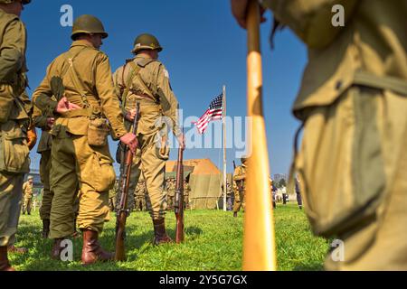 Nijmegen, Gelderland, Niederlande. September 2024. Die Reenactors erhalten vor der Aktion eine Einweisung. Diese Reenactors üben die Nachstellung der „Kreuzung der Waal“. Die Praxis fand am Fluss Waal in einem Überlaufgebiet namens Nevengeul statt. Hier befindet sich auch das Denkmal auf dem Deich. Vor 80 Jahren überquerten 260 Soldaten der 82. Luftlandedivision die Waal in 26 Segelbooten, um die Waal-Brücke gleichzeitig von Süden und Osten anzugreifen. Die Hälfte der 260 Soldaten wurde verletzt und 48 wurden bei dieser Aktion getötet. Es ist nicht bekannt, wie viele deutsche Soldaten starben Stockfoto