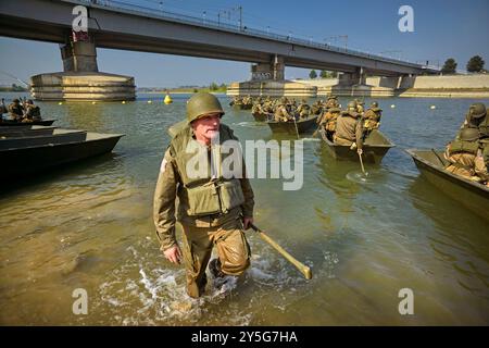 Nijmegen, Gelderland, Niederlande. September 2024. Reenactors üben im Nevengeul neben dem Waal in dem Gebiet, in dem die Überquerung des Waal am 20. September 1944 stattfand. Die Boote, die sie dafür benutzen, sind nicht die ursprünglichen Boote. Diese Reenactors üben die Nachstellung der „Kreuzung der Waal“. Die Praxis fand am Fluss Waal in einem Überlaufgebiet namens Nevengeul statt. Hier befindet sich auch das Denkmal auf dem Deich. Vor 80 Jahren überquerten 260 Soldaten der 82. Luftlandedivision die Waal in 26 Segelbooten, um die Waal-Brücke von Süden und Osten anzugreifen Stockfoto