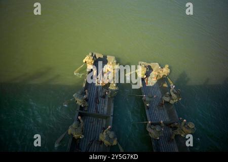 Nijmegen, Gelderland, Niederlande. September 2024. Reenactors üben im Nevengeul neben dem Waal in dem Gebiet, in dem die Überquerung des Waal am 20. September 1944 stattfand. Die Boote, die sie dafür benutzen, sind nicht die ursprünglichen Boote. Diese Reenactors üben die Nachstellung der „Kreuzung der Waal“. Die Praxis fand am Fluss Waal in einem Überlaufgebiet namens Nevengeul statt. Hier befindet sich auch das Denkmal auf dem Deich. Vor 80 Jahren überquerten 260 Soldaten der 82. Luftlandedivision die Waal in 26 Segelbooten, um die Waal-Brücke von Süden und Osten anzugreifen Stockfoto