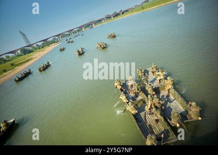 Nijmegen, Gelderland, Niederlande. September 2024. Reenactors üben im Nevengeul neben dem Waal in dem Gebiet, in dem die Überquerung des Waal am 20. September 1944 stattfand. Die Boote, die sie dafür benutzen, sind nicht die ursprünglichen Boote. Diese Reenactors üben die Nachstellung der „Kreuzung der Waal“. Die Praxis fand am Fluss Waal in einem Überlaufgebiet namens Nevengeul statt. Hier befindet sich auch das Denkmal auf dem Deich. Vor 80 Jahren überquerten 260 Soldaten der 82. Luftlandedivision die Waal in 26 Segelbooten, um die Waal-Brücke von Süden und Osten anzugreifen Stockfoto