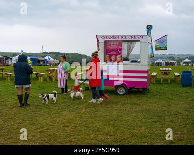 DAME MIT ZWEI HUNDEN VOR DER EISKREM-VAN SAINT MAWGAN VINTAGE-DAMPFRALLYE Stockfoto