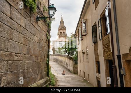 Touristenfrau, die durch die engen Gassen des historischen Zentrums von Santiago de Compestela, Galicien, spaziert. Stockfoto