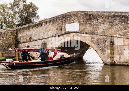 Segelboot unter der niedrigen alten Brücke über den Fluss Thurne im Norfolk Broads National Park. Potter Heigham, Norfolk, East Anglia, England, Vereinigtes Königreich, Stockfoto