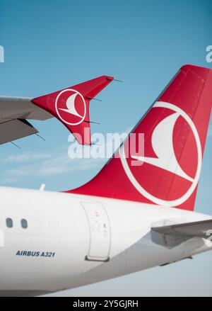 Die Flügelspitze und der Schwanz der Turkish Airlines an einem sonnigen Tag. Weißer Airbus A321 mit rotem vertikalem Stabilisator und Flügelspitze. Klarer blauer Himmel im Hintergrund Stockfoto