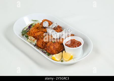 Chicken Lutscher ist eine indische chinesische Vorspeise, die ein gefiedertes Hühnerflügel ist. An einem Ende mit Silberfolie gewickelt und mit Chutney serviert Stockfoto