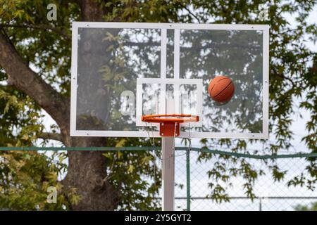 Basketball in der Luft auf Glas Board und Orange Rim ohne Netz – Erfolg oder Misserfolg Konzept Stockfoto