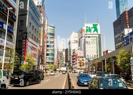 Blick entlang von der mittleren Otakibashi-dori Straße in Shinjuku West. Hochhäuser auf beiden Seiten der zweispurigen Straße. Blauer Himmel und heller Sonnenschein. Stockfoto