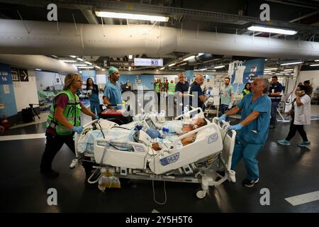 Haifa, Israel. September 2024. Menschen bringen Patienten in eine unterirdische Station im Rambam Medical Center in Haifa, Nord-Israel, 22. September 2024. Die Hisbollah-Truppen im Libanon feuerten am frühen Sonntag etwa 115 Raketen auf Israel ab, wobei einige Gebiete nahe der nördlichen Stadt Haifa erreichten und ihre Reichweite auf bisher nicht zielgerichtete Orte während des anhaltenden Konflikts ausdehnten. Nach dem Raketenangriff kündigte Israels Heimatfront-Kommando an, dass Schulen geschlossen werden und Versammlungen und Bewegungen in allen Gebieten nördlich von Haifa eingeschränkt würden. Quelle: Jamal Awad/Xinhua/Alamy Live News Stockfoto