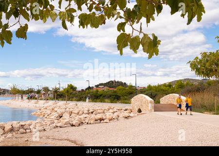 Tribunj, Kroatien - 14. September 2024: Strand und Promenade am Meer mit wenigen Leuten zu Fuß Stockfoto