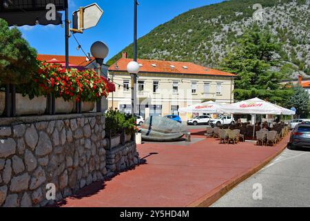 Solkan, Slowenien - 7. September 2024. Gäste genießen das Spätsommerwetter in einer Bar mit Sitzgelegenheiten im Freien auf einem zentralen Platz mit Brunnen in Solkan Stockfoto