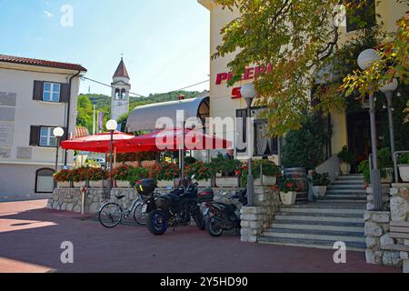 Solkan, Slowenien - 7. September 2024. Gäste genießen das Spätsommerwetter in einem Pizzarestaurant mit Sitzgelegenheiten im Freien auf dem zentralen Solkan-Platz Stockfoto