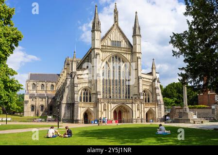 Kathedrale von Winchester mit Menschen, die die Sonne genießen, in der Kathedrale in der Nähe von Winchester Hampshire England Großbritannien GB Europa Stockfoto