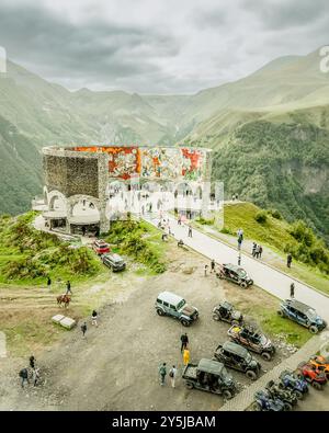 Kazbegi, Georgien - 8. september 2024: Von oben aus der Luft besuchen Touristen das berühmte Wahrzeichen Russland-Georgien-Freundschaftsdenkmal oder den Vertrag von G Stockfoto