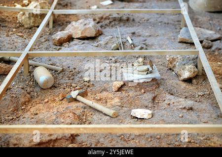 Raster einer Ausgrabung mit Werkzeugen. Archäologie und paläontologisches Konzept Stockfoto