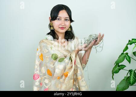 Wunderschöne asiatische Frau in Kurtha für Diwali, die Ausdrücke und Gesten mit LED-Weihnachtslichtern gibt Stockfoto