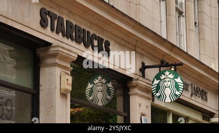 Das Starbucks Logo vor einem Geschäft in der Great Portland Street, London Stockfoto