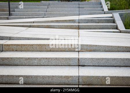 Gefliester Fußgängerweg mit Stufen in der städtischen Umgebung. Stockfoto