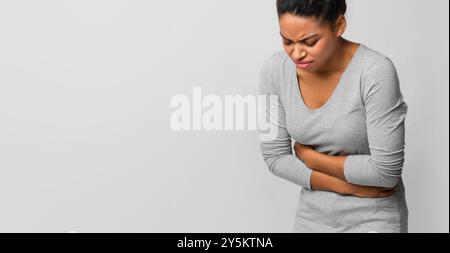 Junge schwarze Frau mit menstruellen Bauchschmerzen Stockfoto