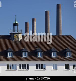 Ein Haus in Wolfsburg mit den vier Kaminen des alten Blockheizkraftwerks der Volkswagen AG als Wahrzeichen, Niedersachsen, Deutschland, Europa Stockfoto