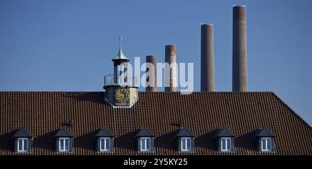 Ein Haus in Wolfsburg mit den vier Kaminen des alten Blockheizkraftwerks der Volkswagen AG als Wahrzeichen, Niedersachsen, Deutschland, Europa Stockfoto