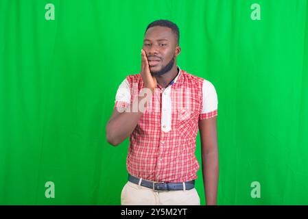 Porträt eines gutaussehenden kranken jungen Mannes, der Hand auf der Wange hält und an Zahnschmerzen leidet. Stockfoto