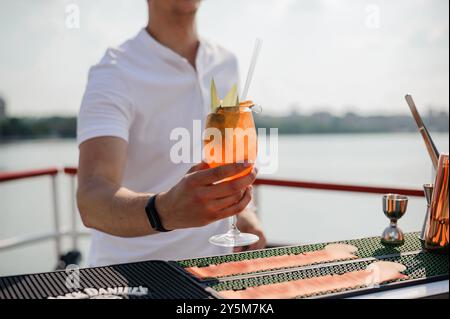 Erfrischender Sommercocktail, serviert vom Bartender in einer malerischen Dachbar mit wunderschönem Ausblick. Stockfoto