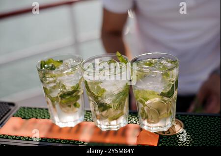 Erfrischende Mojito-Cocktails, die an einem sonnigen Tag am Wasser in entspannter Atmosphäre serviert werden. Stockfoto