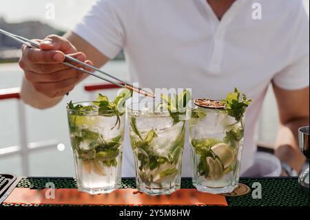 Erfrischende Mojito-Cocktails auf einer sonnigen Terrasse mit Garnelen und Eiswürfeln. Stockfoto