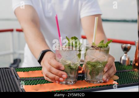 Erfrischende Mojito-Cocktails serviert auf einem Sunny Deck mit Mint Garnish. Stockfoto