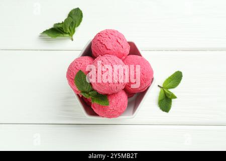 Löffel leckeres Wassermelonensorbet mit Minze in Schüssel auf weißem Holztisch, flach gelegt Stockfoto
