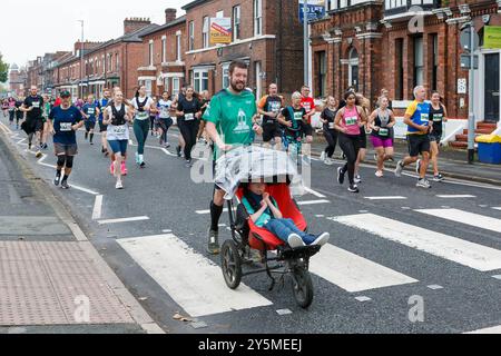 Sonntag, 22. September 2024 – Warrington, Cheshire, England, Vereinigtes Königreich – fand Ein Festival statt, bei dem es frei zu betreten ist, abgesplitterte und gesperrte Straßen gab. Ein Vater schiebt sein Kind in einem Kinderwagen durch die Straßen. Quelle: John Hopkins/Alamy Live News Stockfoto