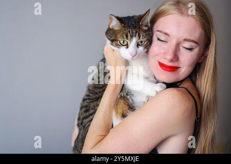 Frau umarmt ihre graue Katze und sehr glücklich. Antistress Stockfoto