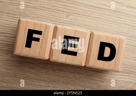 Würfel mit den Buchstaben Fed (Federal Reserve System) auf Holztisch, Draufsicht Stockfoto