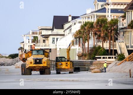 Isle Of Palms, Usa. 12. September 2024. Arbeiter setzen schwere Maschinen ein, um riesige Sandsäcke vor den Strandgrundstücken zu platzieren, um die Erosion der Gezeiten davon abzuhalten, die Fundamente am Strand bei Wild Dunes, 12. September 2024 in Isle of Palms, South Carolina, zu untergraben. Der Klimawandel verursacht immer stärkere Fluten, die Hunderte Meter von den Stränden entlang der Region des Flachlandes entfernt sind. Quelle: Richard Ellis/Richard Ellis/Alamy Live News Stockfoto